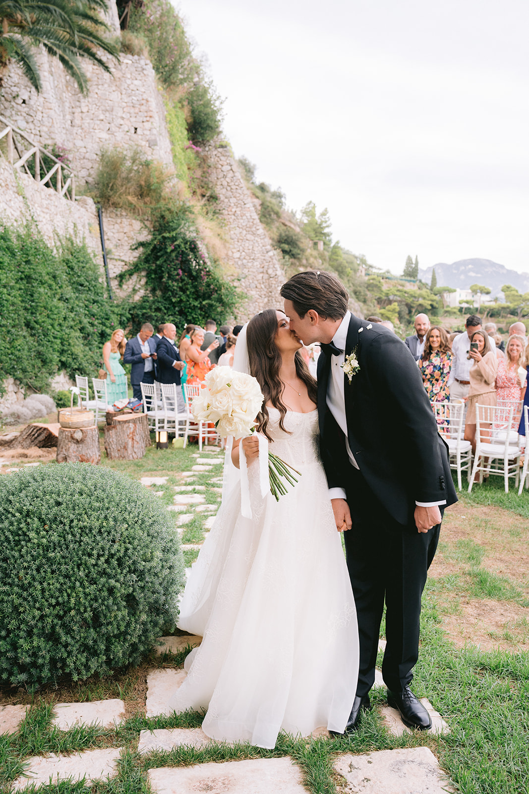 Andrea Gallucci - Destination Wedding Photographer- Amalfi Coast Positano Santorini Barcellona Rome Ravello Paris New York documentary wedding photo of the bride and groom kissing after wedding ceremony