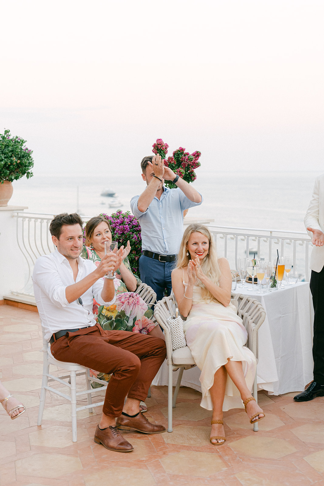 Andrea Gallucci - Destination Wedding Photographer- Amalfi Coast Positano Santorini Barcellona Rome Ravello Paris New York guest clapping during wedding speech moment with Amalfi Coast backdrop