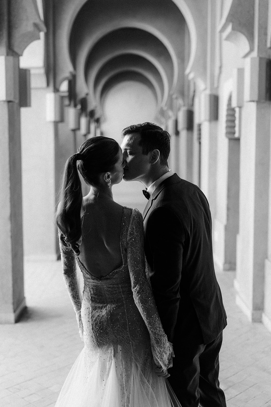 Bride and groom sharing a quiet moment under the arches of Amanjena’s Moroccan resort