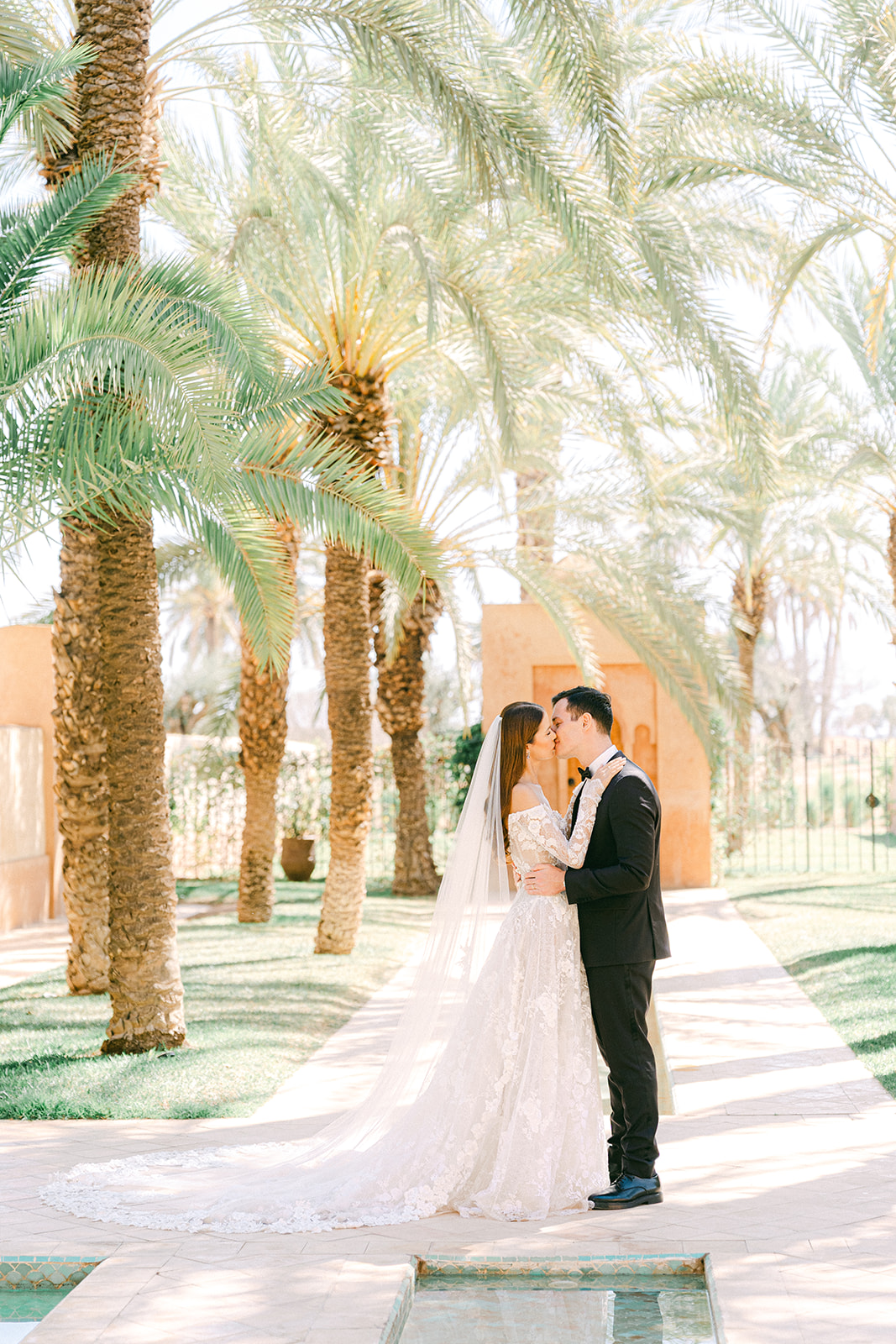 Romantic photos of the couple at Amanjena, with Moroccan architecture in the background and palm trees