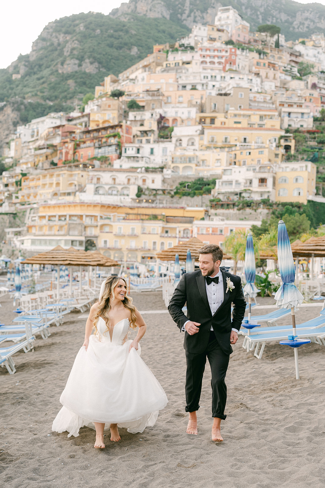 Andrea Gallucci - Destination Wedding Photographer- Amalfi Coast Positano Santorini Barcellona Rome Ravello Paris New York bride and groom running in the Positano beach