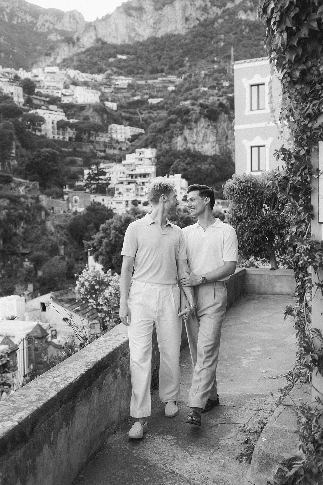 Same-sex couple walking cobblestone streets for outdoor engagement photos in Amalfi