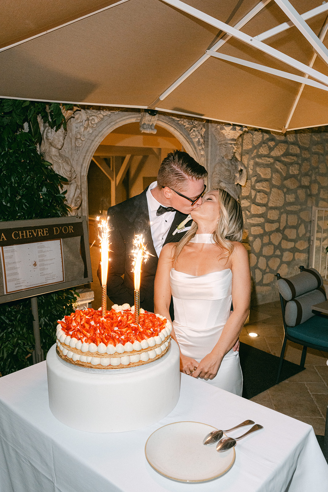 Bride and groom sharing a kiss during cake cutting