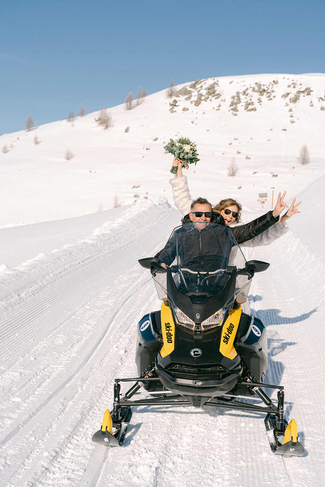 wedding couple on a snowmobile to go to their wedding reception