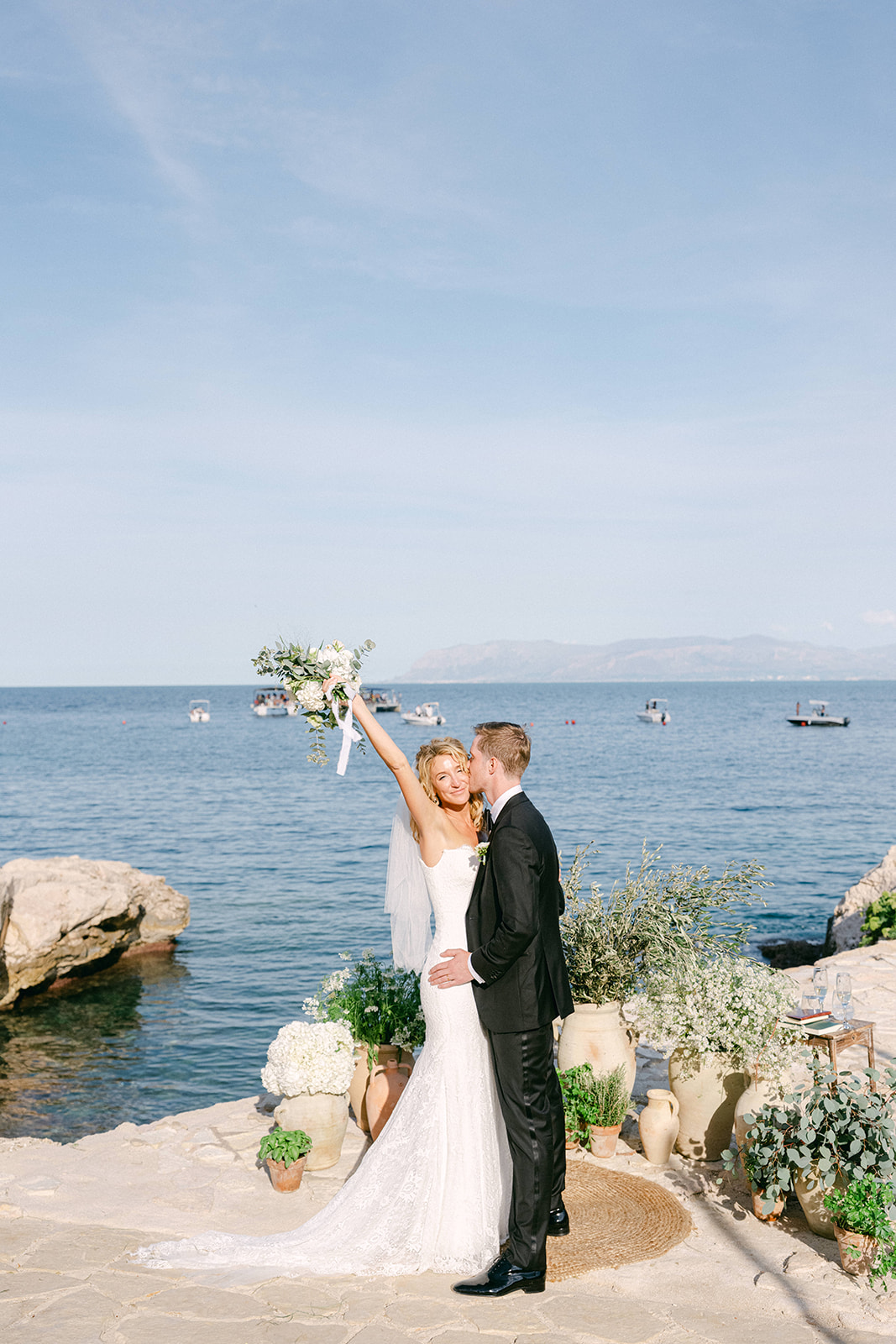 Bride and groom exchanging vows on the rocky terrace at Tonnara di Scopello during their wedding in Sicily with the sea in the background.