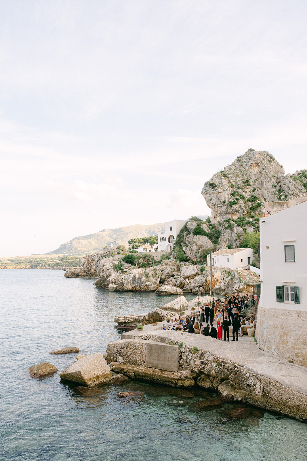 Panoramic shot of the historic fishing estate at Tonnara di Scopello surrounded by mountains and Mediterranean sea views.