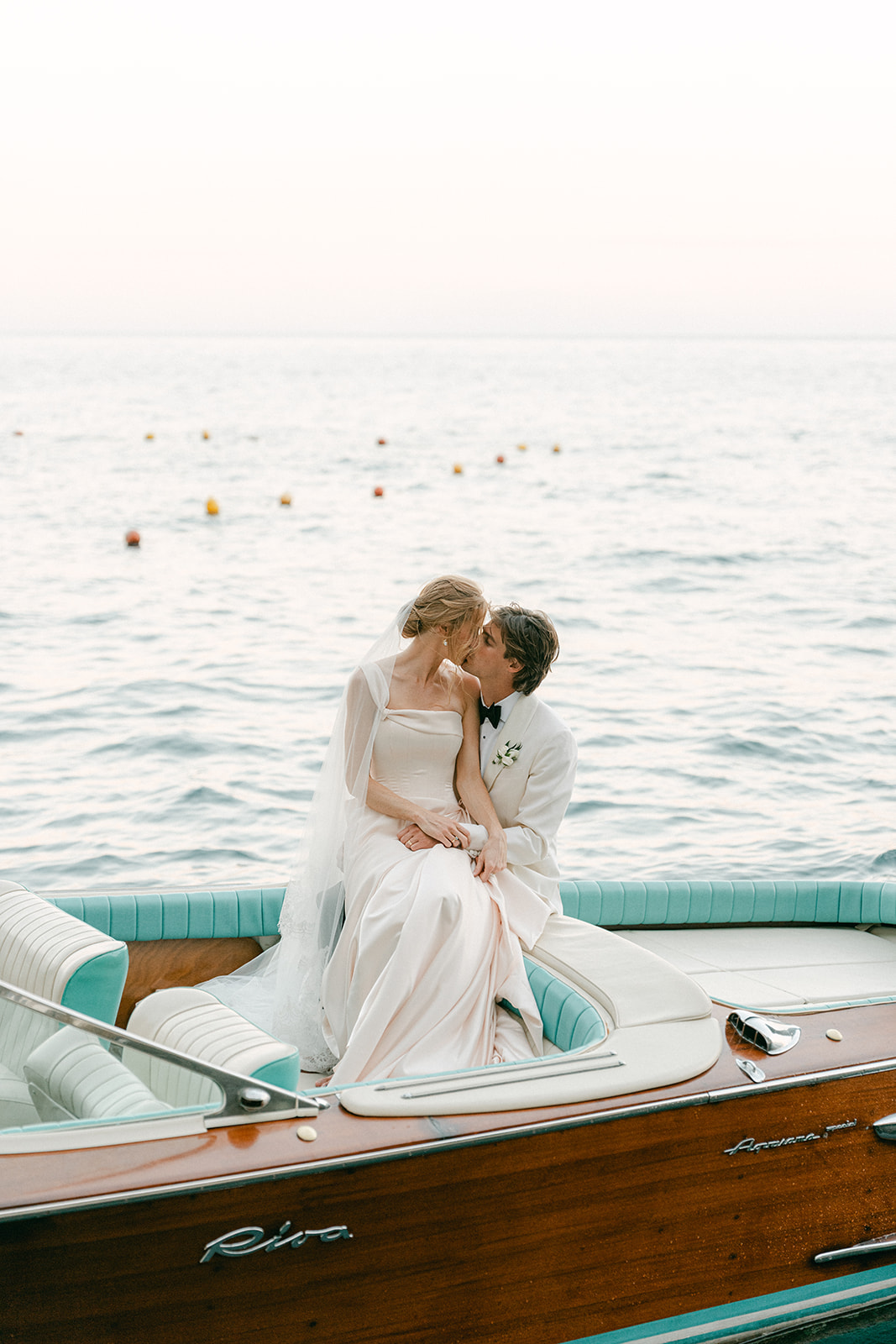 Couple sharing a quiet moment aboard a private yacht following their wedding on the Amalfi Coast, showcasing luxury destination wedding photography in Italy.