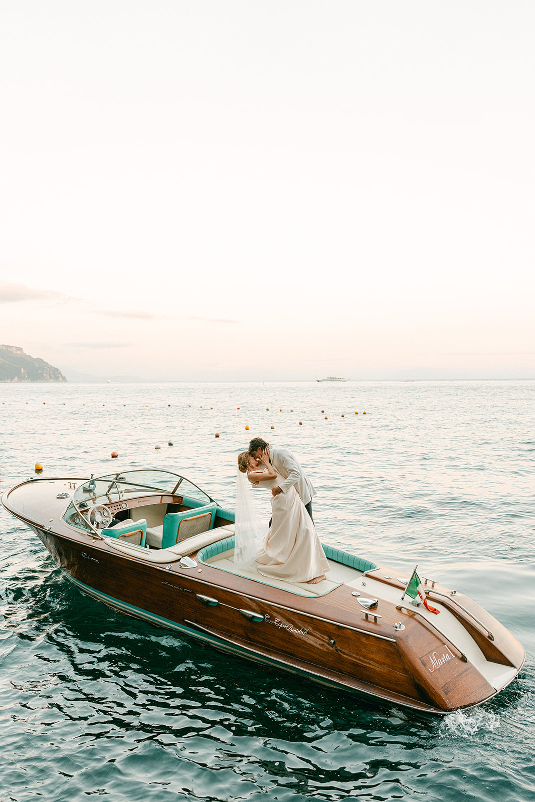 Romantic post-ceremony yacht photos on the Amalfi Coast, bride and groom celebrating with a luxury boat experience and coastal Italian backdrop