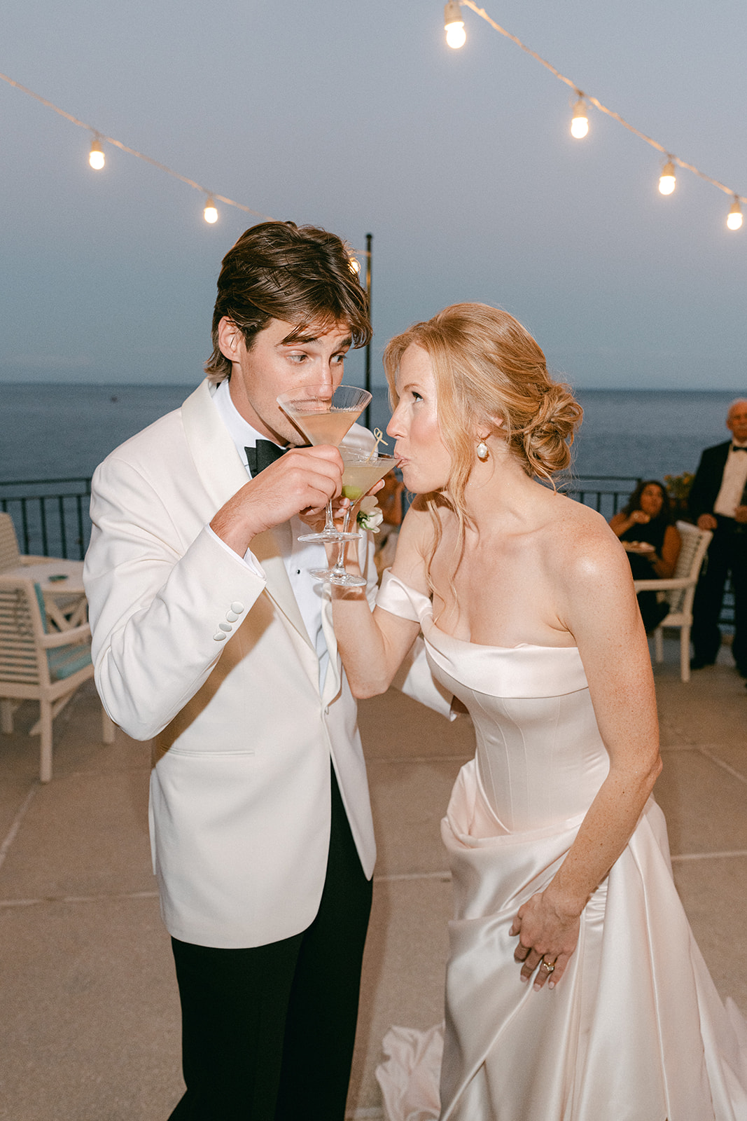 Bride and groom cheers at a martini tower during Amalfi Coast wedding.