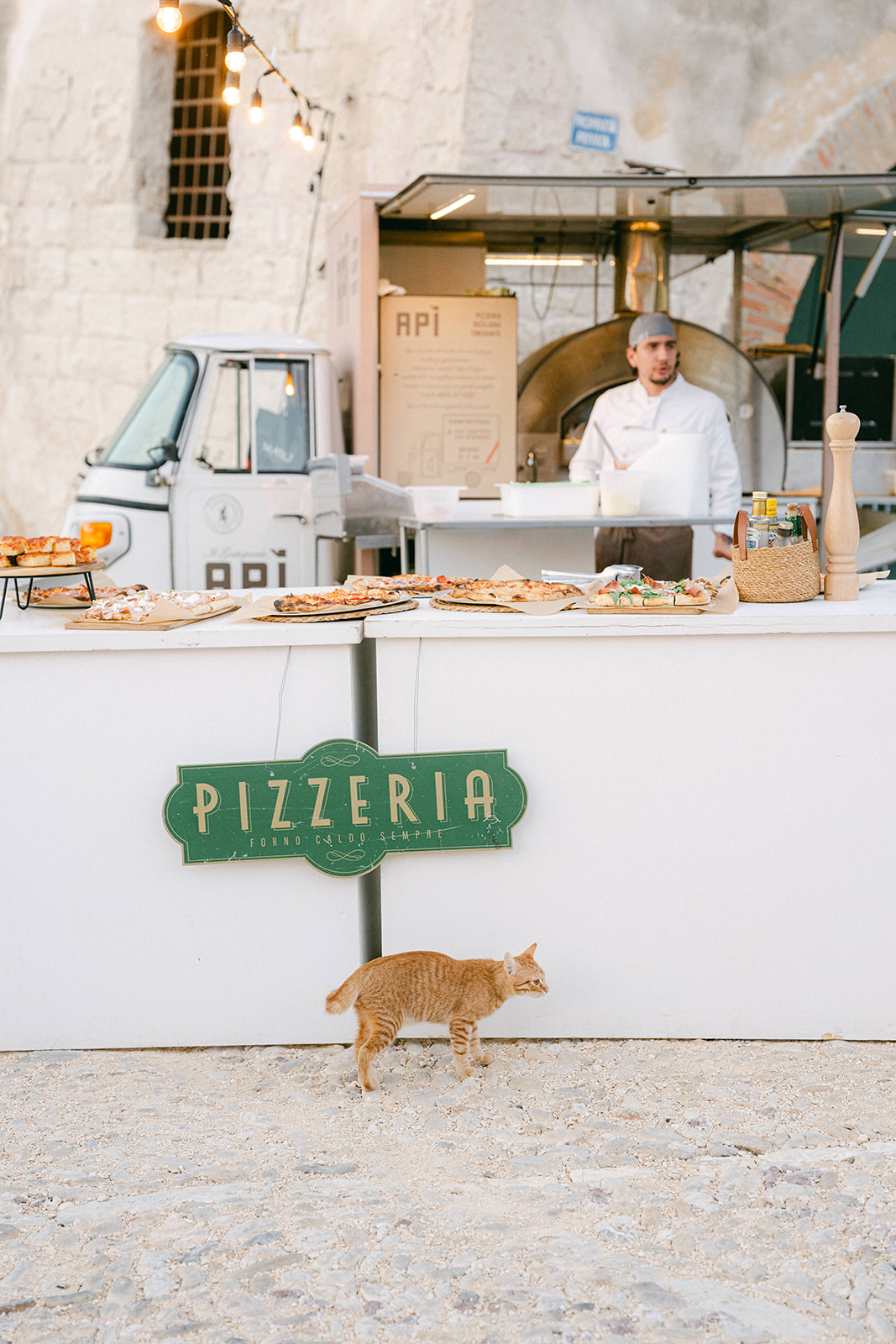 Outdoor pizza night setup with casual tables and seaside views for the Tonnara di Scopello wedding weekend.