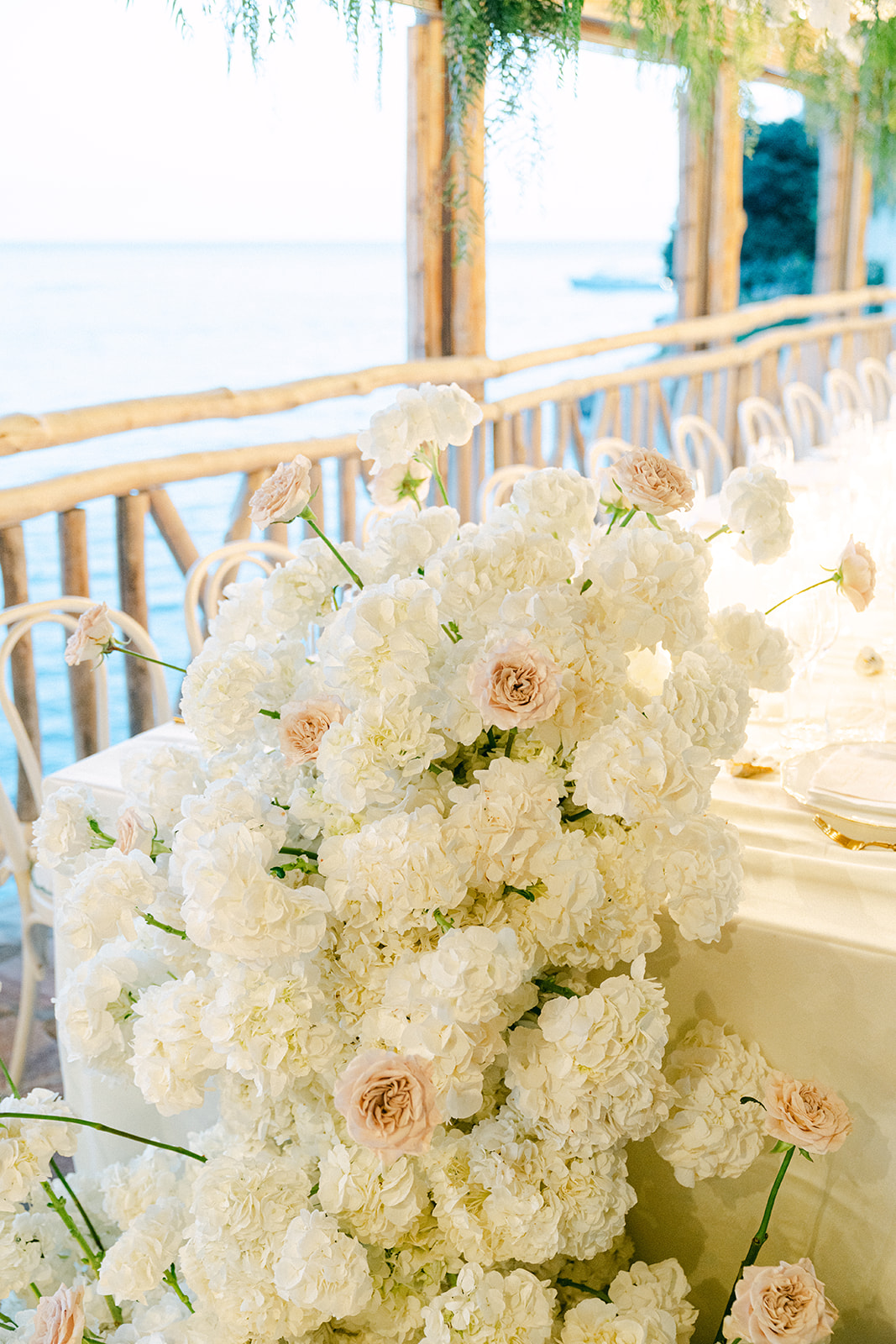 White floral arrangements and draped greenery at Italian wedding