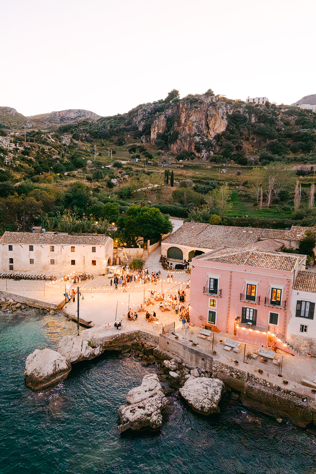 Overview of the rustic stone buildings at Tonnara di Scopello showing its authentic Sicilian architecture and coastal setting.
