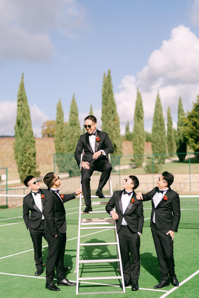Groom and groomsmen portrait on tennis court at Italian villa wedding