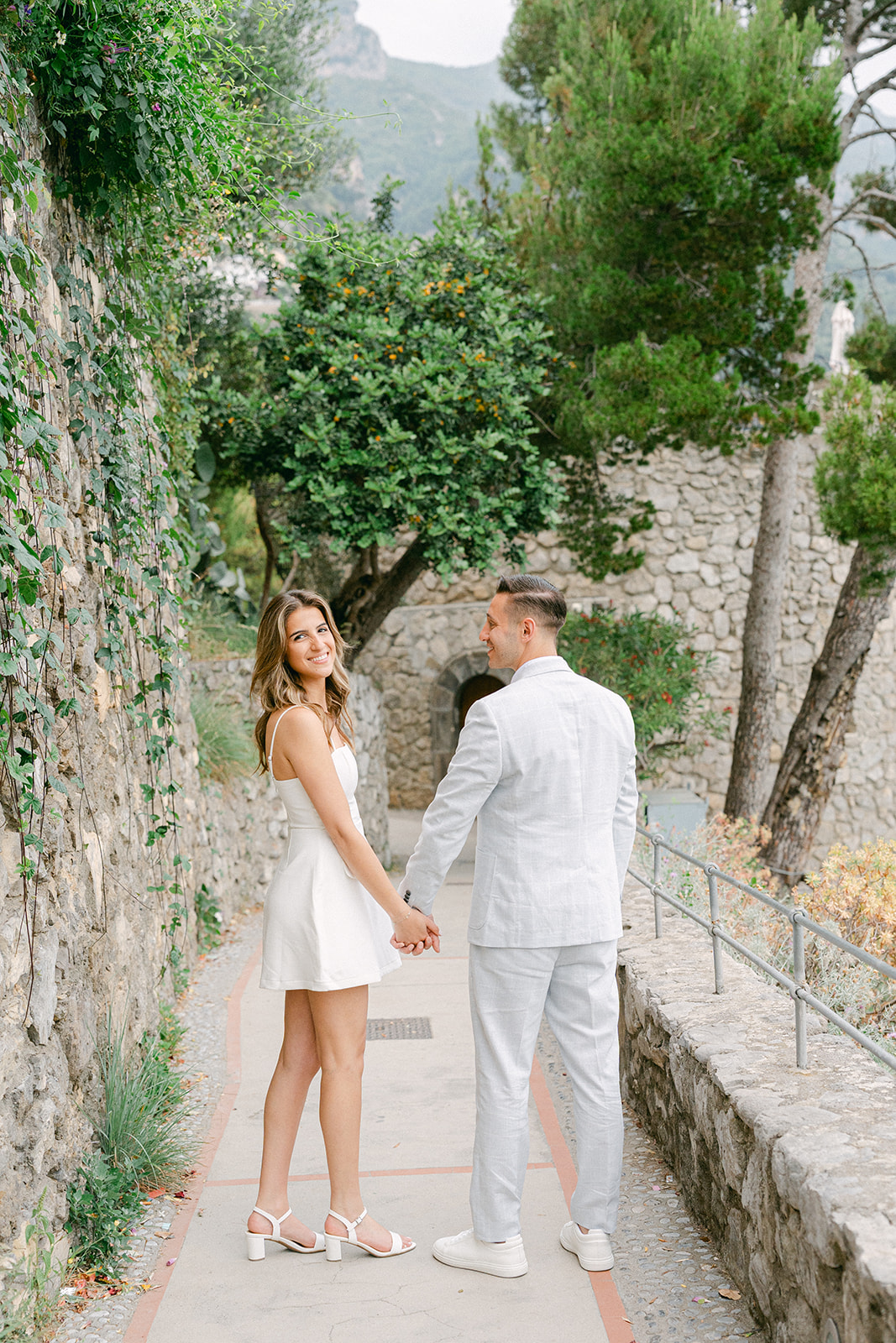 Couple walking through Positano streets during Amalfi Coast vacation engagement photos
