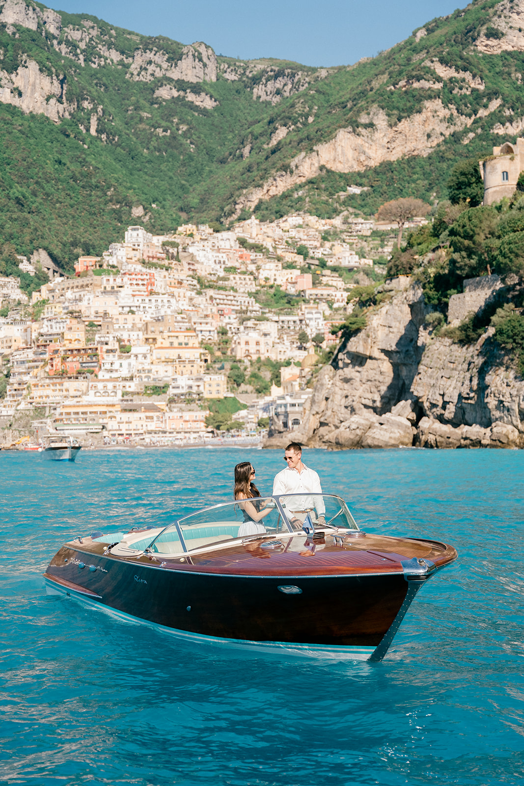 Amalfi Coast boat engagement photos with dramatic coastal cliffs in the background
