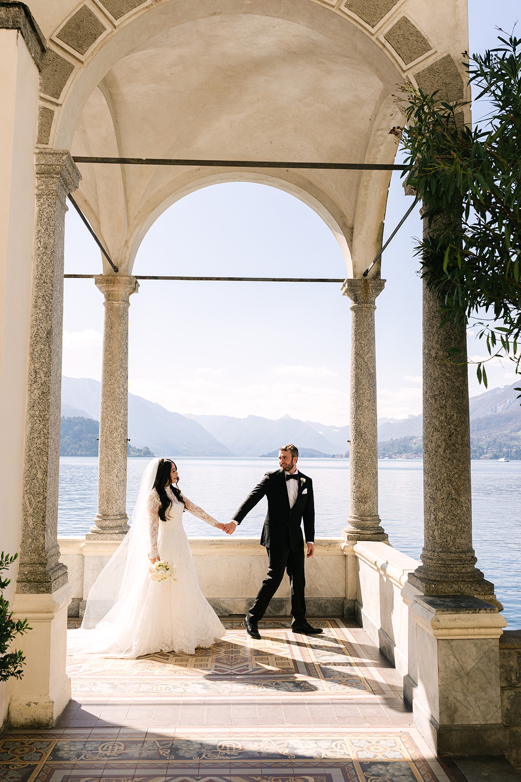 Lake Como elopement couple holding hands by the lake