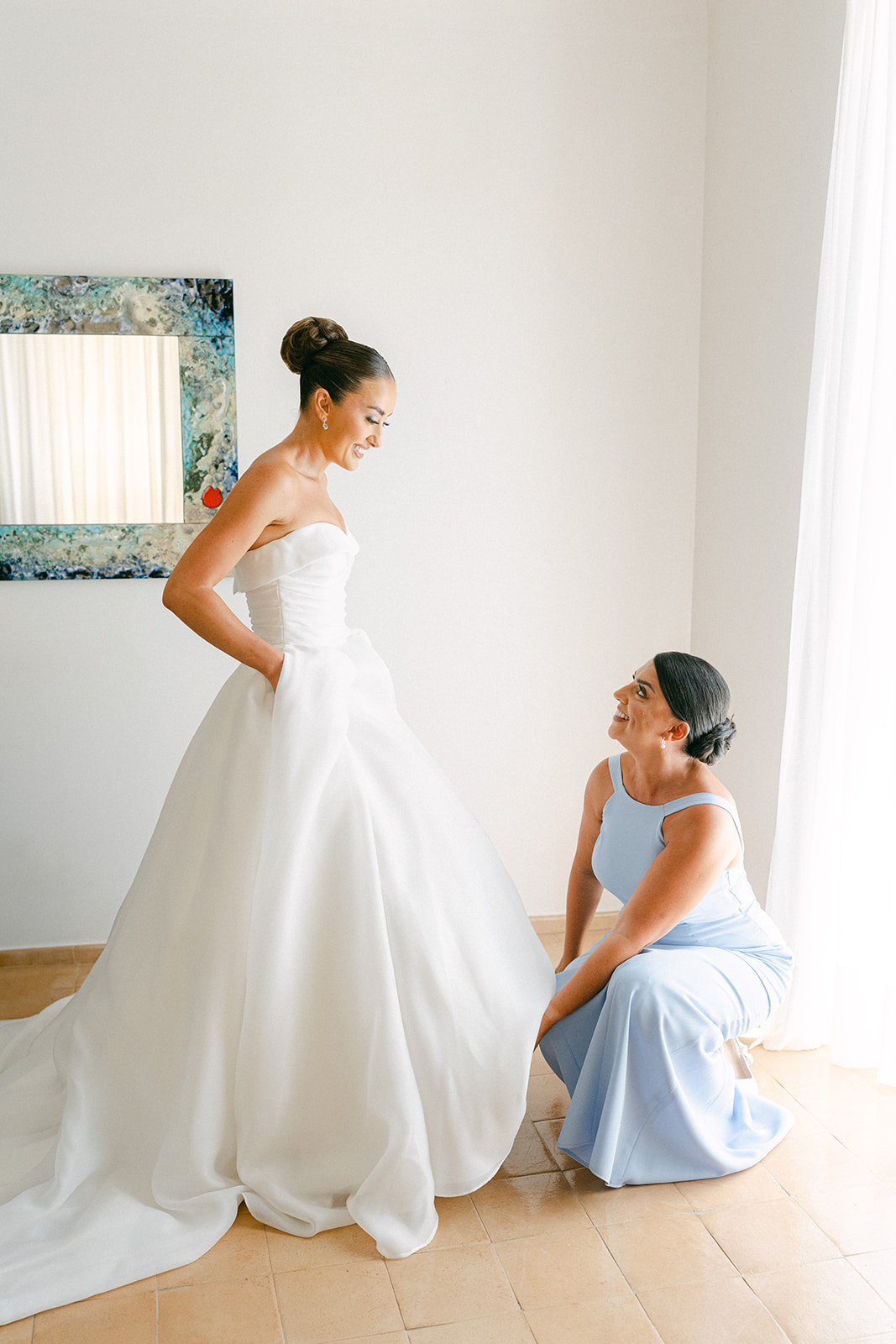 Maid of honour of the bride fixing dress during getting ready pictures wedding