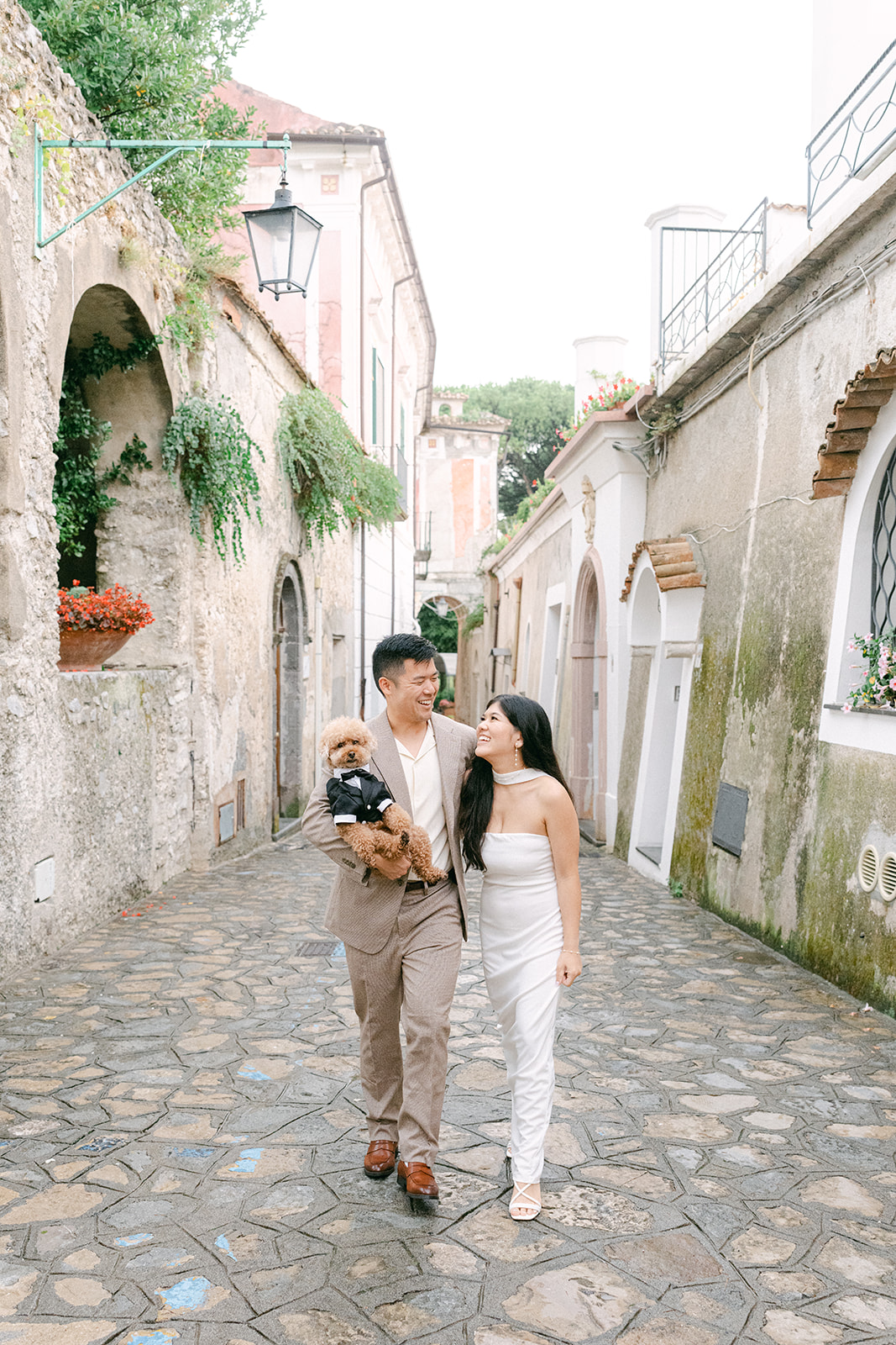 Couple walking with dog during engagement photos in Ravello