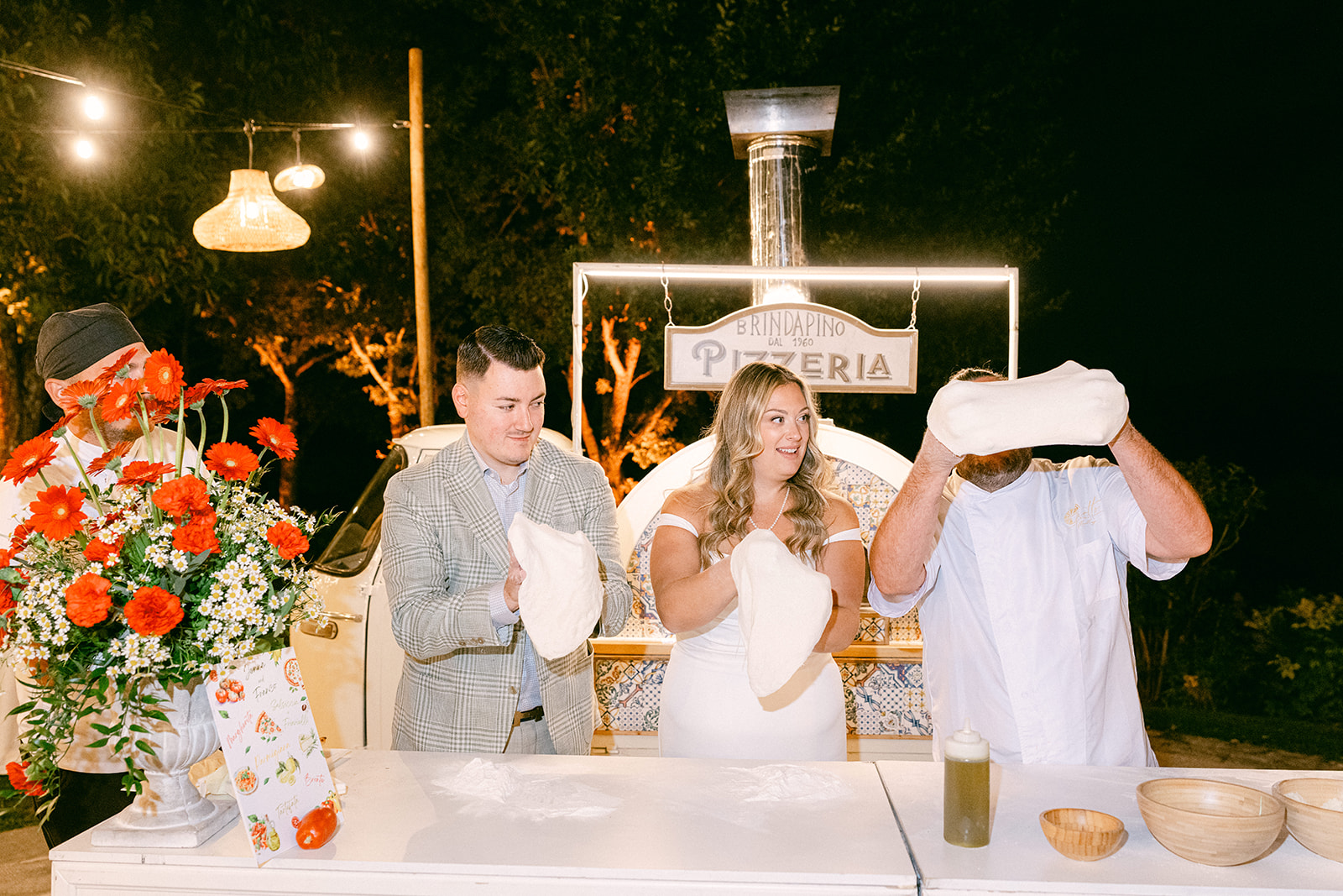 Couple making pizza during their Tuscany wedding weekend at Borgo Corsignano