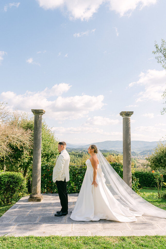 Candid wedding photography for first look at Borgo Corsignano overlooking the Tuscan hills