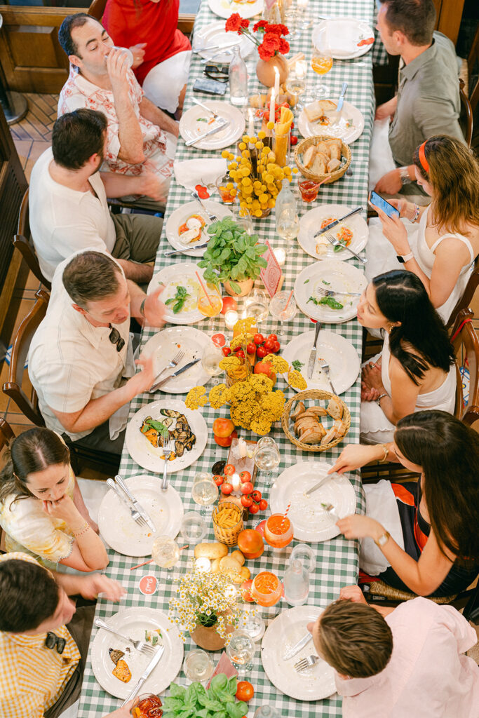 Guests gathered around long tables at an Italy wedding welcome party