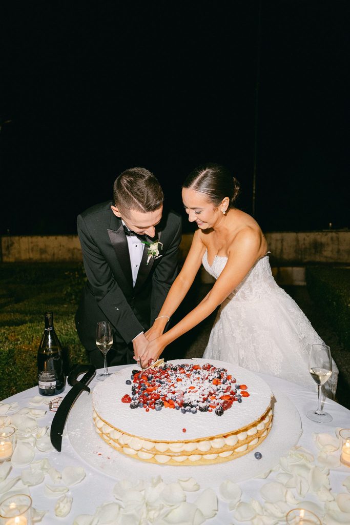 Bride and groom celebrating with a traditional millefoglie cake at Villa Corsini